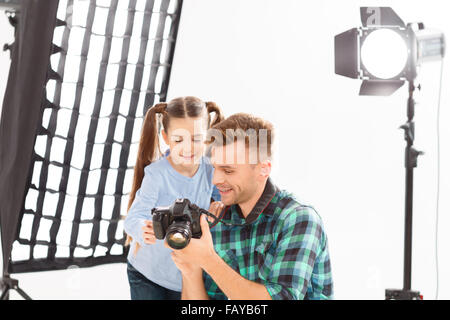 Il fotografo e la bambina sta rivedendo le foto. Foto Stock