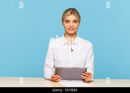 Piacevole annunciatore TV seduti a tavola Foto Stock