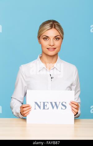 Piacevole annunciatore TV seduti a tavola Foto Stock