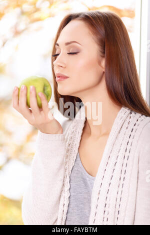 Donna con gli occhi chiusi gode l'odore di apple. Foto Stock