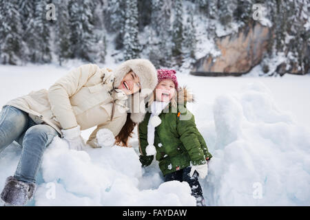 Inverno all'aperto può essere favola-maker per bambini o anche per adulti. Ritratto di sorridere la madre e il bambino che gioca con la neve o Foto Stock