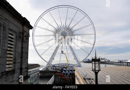 Brighton Regno Unito 6 Gennaio 2016 - operai di scala del Brighton ruota sul lungomare per effettuare la manutenzione invernale pronto a lavorare per la nuova stagione . La ruota sorge a 45 metri di diametro e offre vedute del litorale circostante architettura e i punti di riferimento Credito: Simon Dack/Alamy Live News Foto Stock