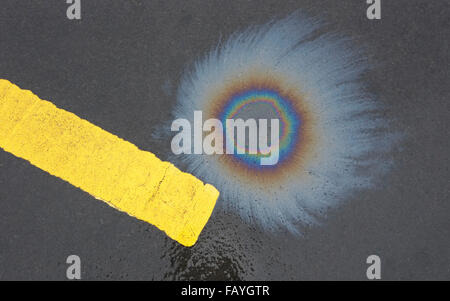 olio colorato fuoriuscito su una superficie stradale asfaltata scura Foto Stock