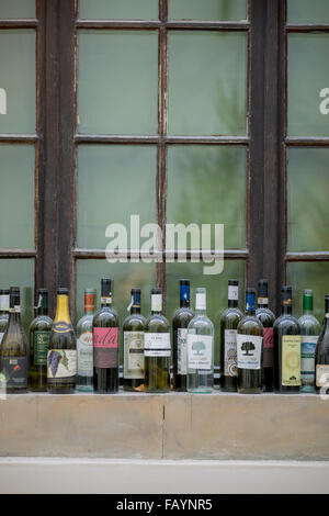 Svuotare le bottiglie di vino in piedi sul davanzale Foto Stock