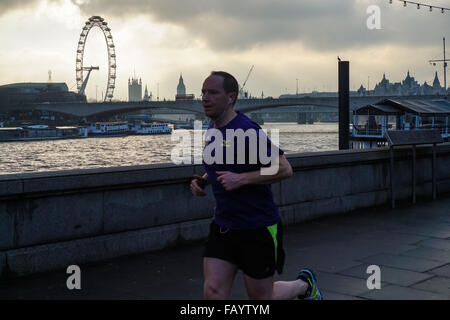 Uomo che corre lungo il fiume Tamigi in London, England Regno Unito Regno Unito Foto Stock