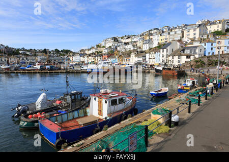 Piccole barche da pesca ormeggiate ormeggiato a New Quay, Brixham, Devon, su un glorioso giorno d'estate; la città sorge in background Foto Stock