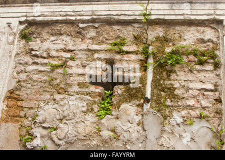 Croce nel lato del mattone di decadimento cripta iconico Recoleta cimitero, Buenos Aires, Argentina. Foto Stock