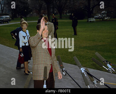 Washington, DC, Stati Uniti d'America, 27 dicembre, 1984 Presidente Ronald Reagan onde ai giornalisti al di fuori del Sud Portico come lui e la First Lady Nancy Reagan prepararsi a bordo uno marino per il volo per Andrews AFB per viaggio in California. Credito: Mark Reinstein Foto Stock