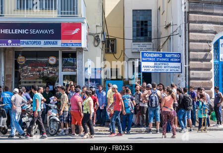 I rifugiati di attendere in linea per acquistare i biglietti del traghetto per lasciare l'isola di Lesbo dopo elaborazione ufficiale. Foto Stock