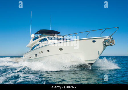 Un privato di lusso yacht a motore in modo sul mare tropicale con onda di prua Foto Stock