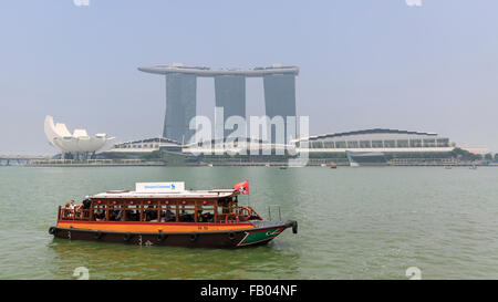 Un sulla Bumboat Tradizionale crociere in Marina Bay, con il Marina Bay Sands Hotel in background, Singapore Foto Stock