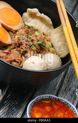 Mie Medan, stile cinese noodle soup da Medan. Servito con carne di maiale tagliata a dadini, Duck egg, gnocchi e polpette di pesce. Foto Stock