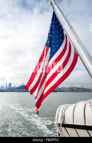 Bandiera americana con skyline di San Francisco in distanza Foto Stock