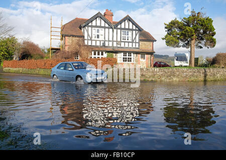 Combe, Herefordshire, UK. Il 7 gennaio, 2016. Regno Unito meteo. Una vettura negozia l'allagato B4362 a Combe sul confine England-Wales che collega Presteigne, Powys con Shobdon, Herefordshire. Il locale Hindwell Brook ha scoppiare le sue banche come grandi volumi di acqua continuano a fluire verso il basso da monte in Galles. Foto Stock