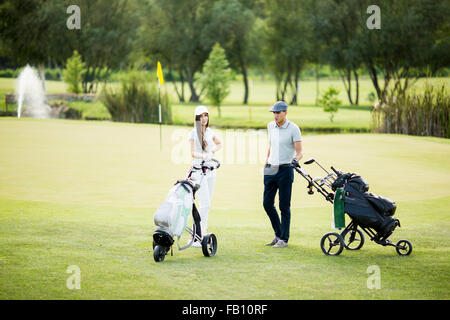 Coppia giovane a carrello da golf Foto Stock