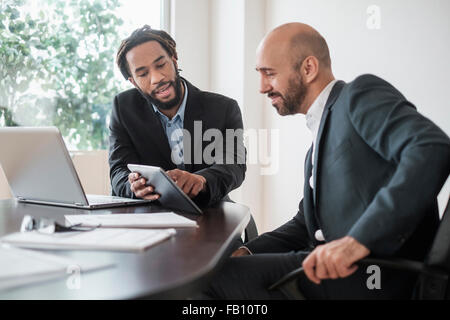 Due imprenditori lavora con tavoletta digitale da scrivania in ufficio Foto Stock