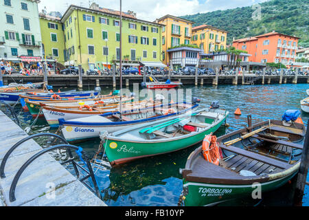 Lago di Garda boardwalk con le case, i turisti e le barche a Torbole, Italia. Foto Stock