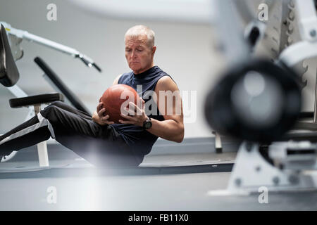 L uomo nel club salute esercita con sfera Foto Stock