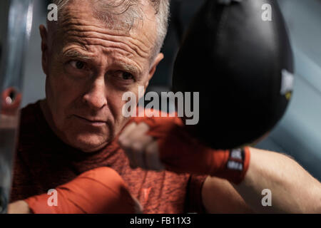 L uomo nel club salute colpendo Speed bag Foto Stock