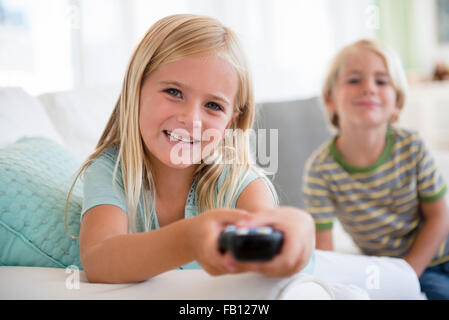 Ragazzo (4-5) e la ragazza (6-7) seduto sul divano Foto Stock