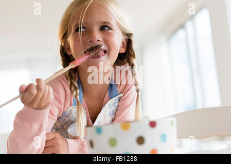 La ragazza (6-7) mangiare il cioccolato Foto Stock