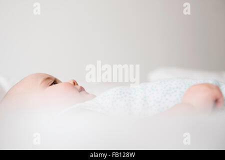 Baby girl (12-17 mesi) sdraiato sul letto Foto Stock