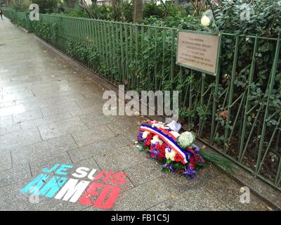 Parigi, Francia. Il 6 gennaio, 2016. Le parole "Je suis Ahmed' e fiori contrassegnare il luogo dove il 7 gennaio 2015, i terroristi ucciso funzionario di polizia Ahmed Merabet dopo il loro attacco a Charlie Hebdo, sul Boulevard Richard Lenoir a Parigi, in Francia, il 6 gennaio 2016. La pavimentazione della scena del crimine è direttamente adiacente ad un parco giochi. Una lapide commemorativa per Merabet è affissa alla recinzione. Foto: GERD ROTH/DPA/Alamy Live News Foto Stock