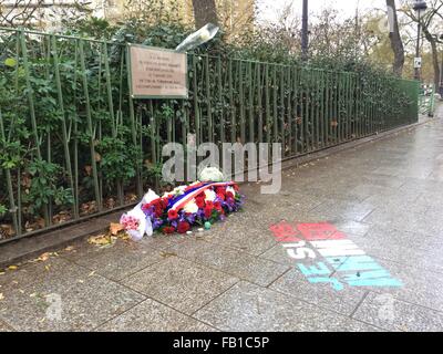 Parigi, Francia. Il 6 gennaio, 2016. Le parole "Je suis Ahmed' e fiori contrassegnare il luogo dove il 7 gennaio 2015, i terroristi ucciso funzionario di polizia Ahmed Merabet dopo il loro attacco a Charlie Hebdo, sul Boulevard Richard Lenoir a Parigi, in Francia, il 6 gennaio 2016. La pavimentazione della scena del crimine è direttamente adiacente ad un parco giochi. Una lapide commemorativa per Merabet è affissa alla recinzione. Foto: GERD ROTH/DPA/Alamy Live News Foto Stock