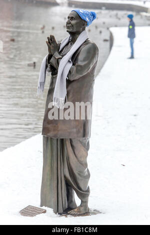 Statua di Sri Chinmoy permanente sulla banca del fiume di Vltava con un cappello e una sciarpa intorno al suo collo in una fresca snowy Praga Repubblica Ceca Foto Stock