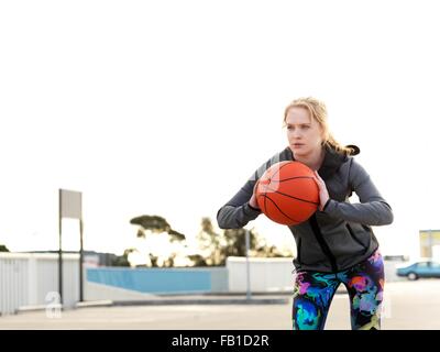 Ritratto di giovane donna giocatore di basket la pratica di buttare in parcheggio Foto Stock