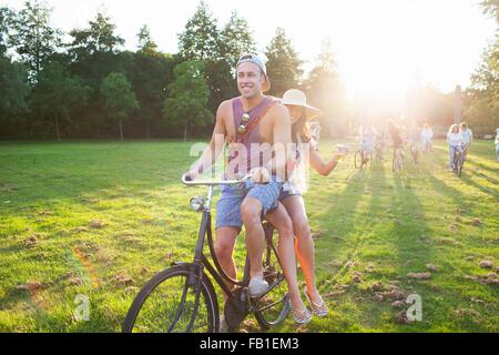 La Folla di partygoing adulti arrivano su cicli di Sunset Park party Foto Stock