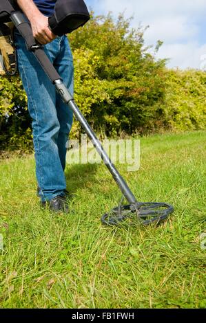 Vista ritagliata di uomo maturo di erba di ricerca utilizzando il rilevatore di metallo Foto Stock