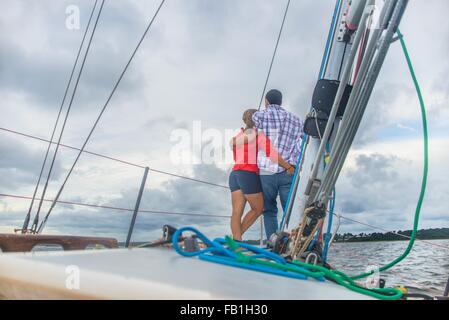 Vista posteriore del giovane sulla prua di bracci intorno a ciascun altro Foto Stock