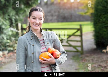 Ritratto di donna azienda mele e zucca al Castello di Thornbury, South Gloucestershire, Regno Unito Foto Stock