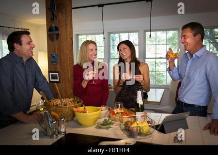 Due coppie mature di bere vino a cena Foto Stock