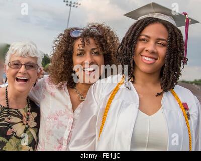 Ragazza adolescente con la madre e la nonna alla cerimonia di consegna dei diplomi Foto Stock