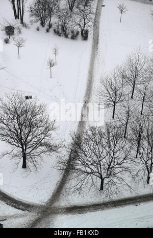 Berlino, Germania. Il 7 gennaio, 2016. Un ciclista su un incrocio di sentieri contrastando un paesaggio innevato a Berlino, Germania, 7 gennaio 2016. Dopo un lieve dicembre, il nuovo anno 2016 inizia con il freddo e la neve. Foto: Jens KALAENE/dpa/Alamy Live News Foto Stock