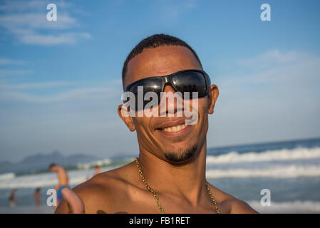 Sulla spiaggia di Copacabana, il giovane uomo che pongono, Rio de Janeiro, Brasile Foto Stock