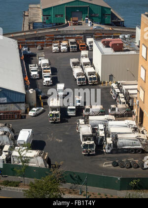 Immondizia camion riempire il parcheggio di un impianto di smaltimento dei rifiuti in Manhattan Quartiere Meatpacking dal fiume Hudson, New York City. Foto Stock