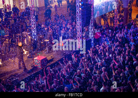 Pubblico entusiasta membri onda alla neve artificiale nel corso di una fase di notte rock 'n' roll concerto a San Clemente, CA, shopping mall. Nota maestro di cerimonie a sinistra. Foto Stock