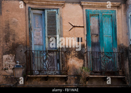 Italiano antico casale in pietra davanti con otturatore verde persiane e balcone a Tropea Foto Stock