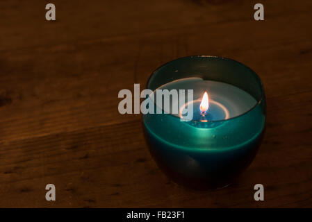 Blue candela accesa su un tavolo di legno Foto Stock