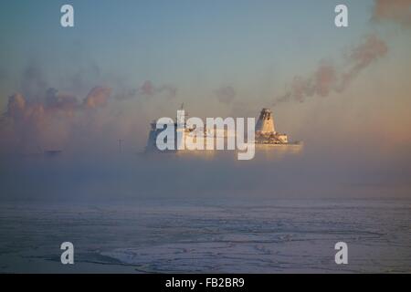 Traghetto in arrivo al porto di Helsinki in un freddo inverno mattina nel mezzo del fumo di mare Foto Stock