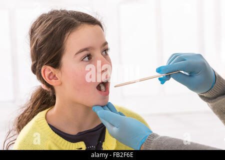 Donna medico esamina una giovane ragazza in gola Foto Stock