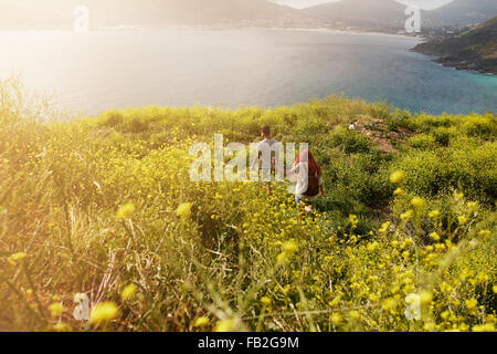 Giovane escursioni verso la costa, camminando sul percorso attraverso prati, in un giorno di estate. Foto Stock