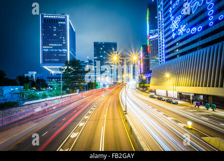 Una lunga esposizione di traffico su Connaught Road e grattacieli di notte, a Hong Kong, Hong Kong. Foto Stock