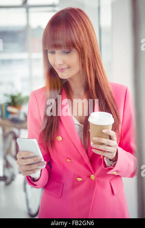 Hipster imprenditrice azienda tazza da caffè e lo smartphone Foto Stock