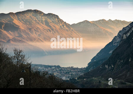 Tramonto nelle montagne che circondano il Lago di Garda e vedute della città di Riva del Garda, Italia Foto Stock