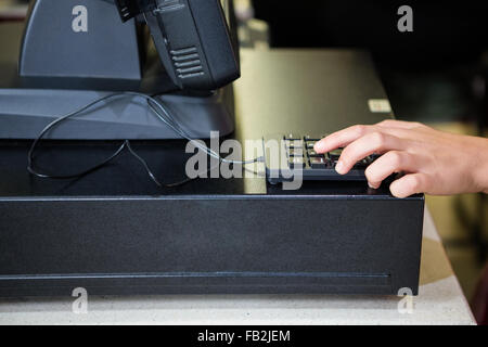 Womans mano utilizzando la calcolatrice Foto Stock