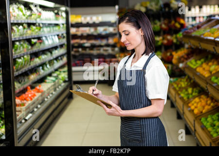 Bella bruna donna prendendo nota in corridoio Foto Stock